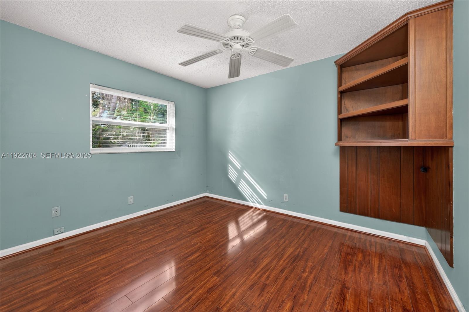 969 Northwest 8th Street Boca Raton, FL 33486 - Photo 24 of 38 a view of an empty room with a window and wooden floor