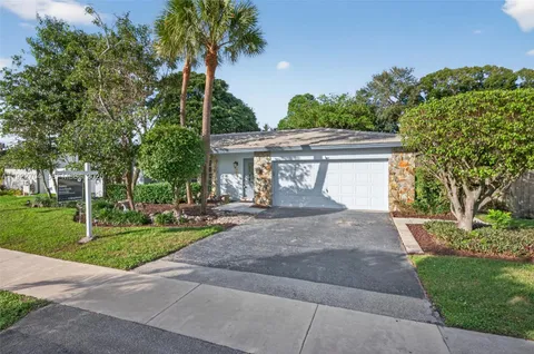 a view of a house with garden and trees