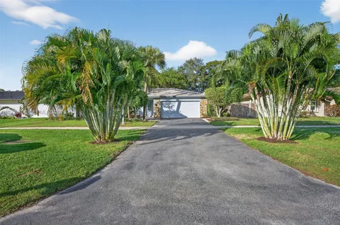 a front view of a house with a yard and a garden