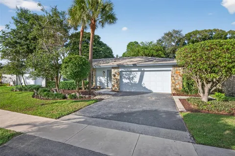 a view of a house with a yard and potted plants