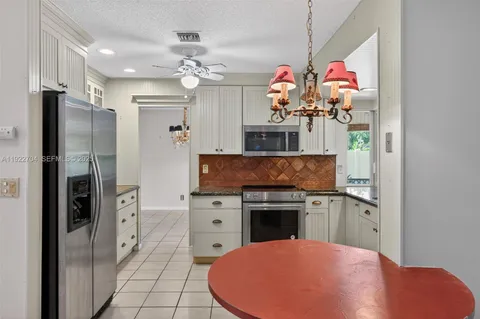 a kitchen with stainless steel appliances granite countertop a refrigerator and a stove