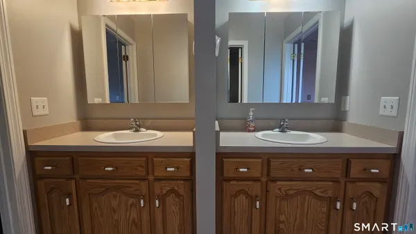 an empty room with windows and chandelier fan