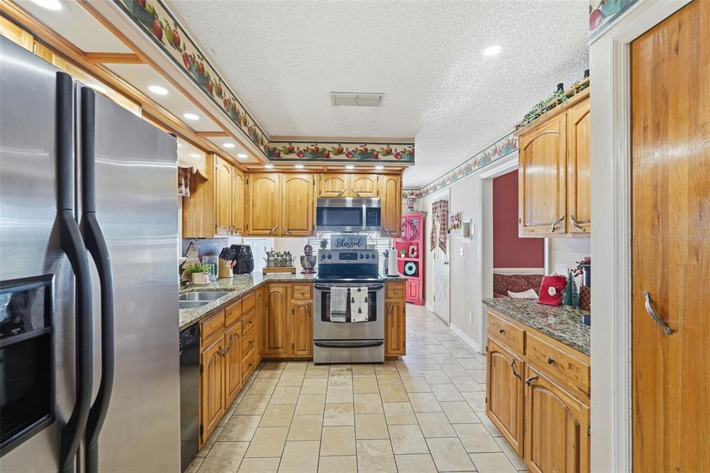 2911 Walker Road Lakeland, FL 33810 - Photo 13 of 70 a kitchen with stainless steel appliances granite countertop a refrigerator and a stove