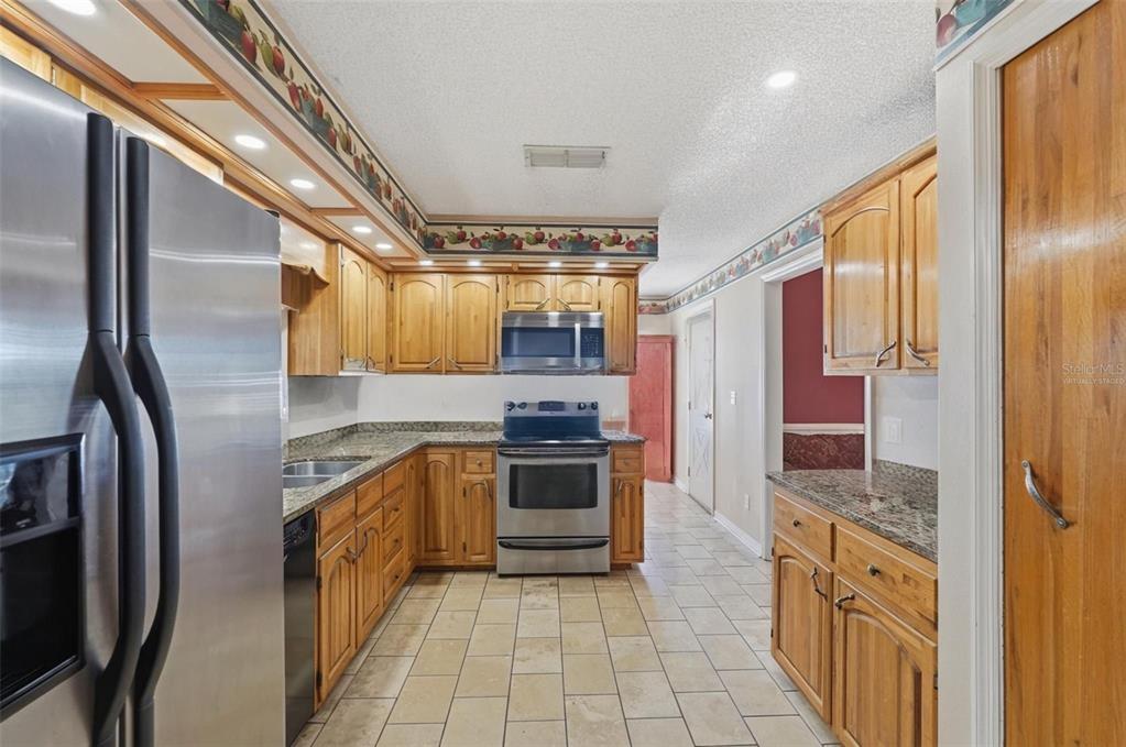 2911 Walker Road Lakeland, FL 33810 - Photo 14 of 70 a large kitchen with stainless steel appliances granite countertop a refrigerator and a stove