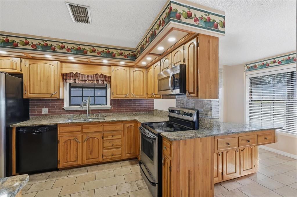 2911 Walker Road Lakeland, FL 33810 - Photo 16 of 70 a kitchen with stainless steel appliances granite countertop a sink and cabinets