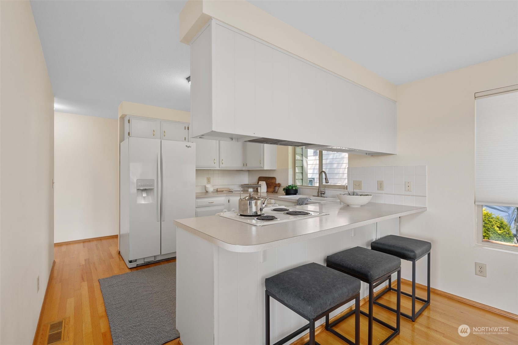 1201 North 28th Place Renton, WA 98056 - Photo 6 of 25 a kitchen with stainless steel appliances granite countertop a sink a stove a refrigerator and island with wooden floor