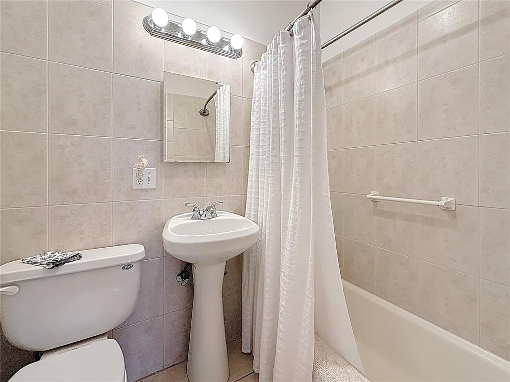 7050 Sunset Way, Unit 22 St. Pete Beach, FL 33706 - Photo 20 of 30 a bathroom with a sink a toilet and shower