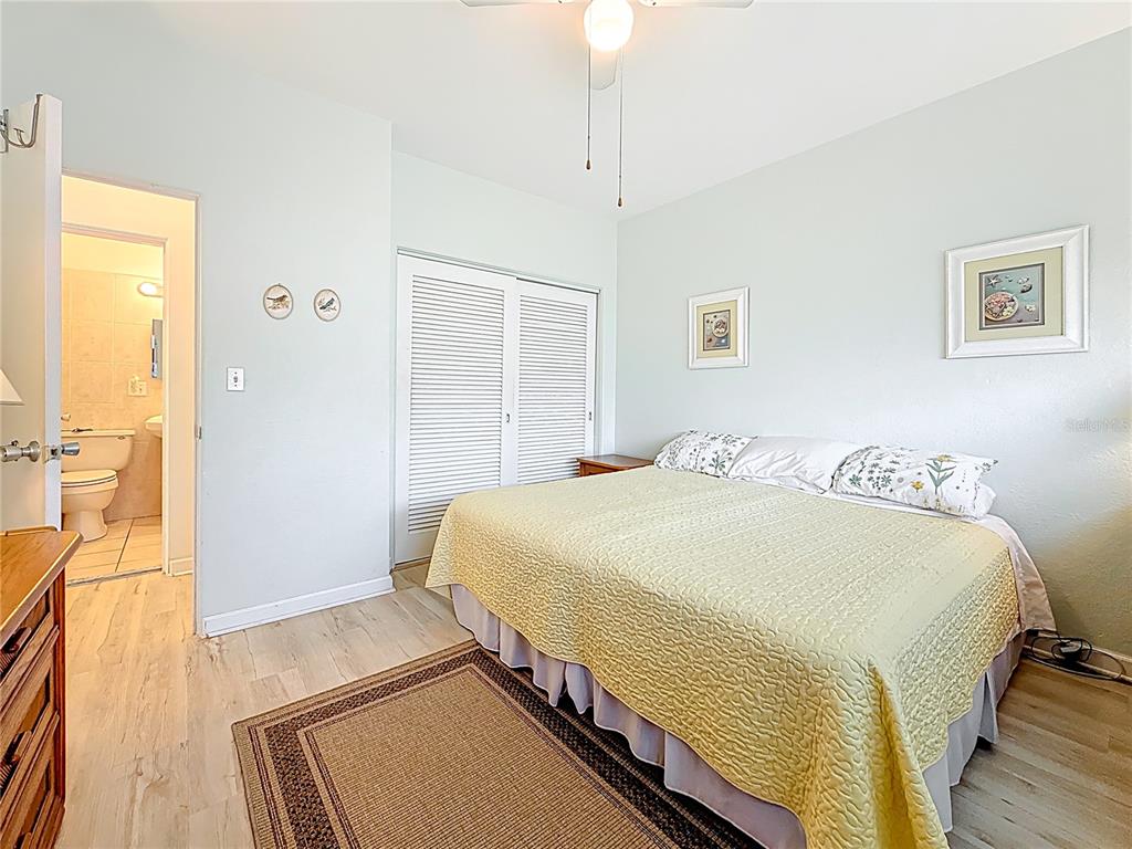 7050 Sunset Way, Unit 22 St. Pete Beach, FL 33706 - Photo 22 of 30 a bedroom with a bed and wooden floor