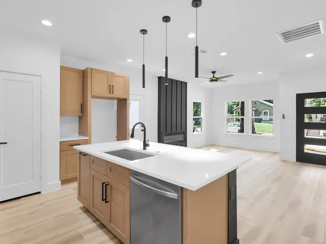 a kitchen with stainless steel appliances granite countertop a sink a refrigerator and a sink