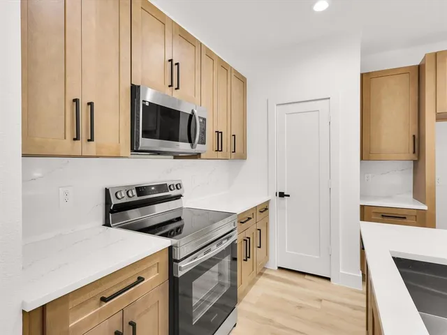 a kitchen with stainless steel appliances a stove microwave and cabinets