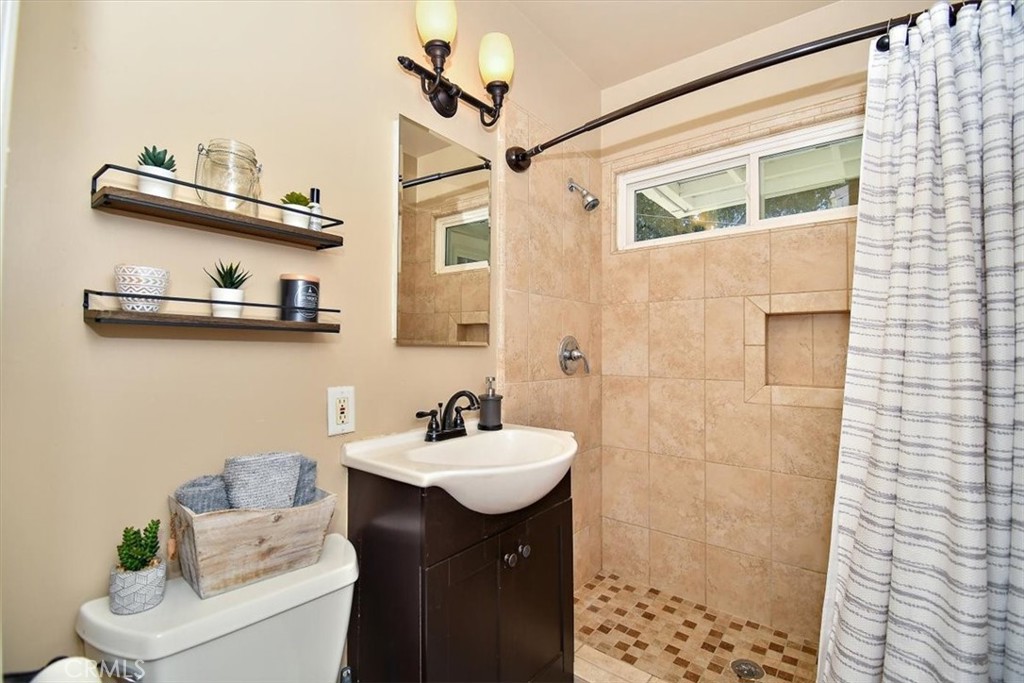 3315 Spring Garden Street Riverside, CA 92501 - Photo 25 of 38 a bathroom with a sink a mirror and a shower