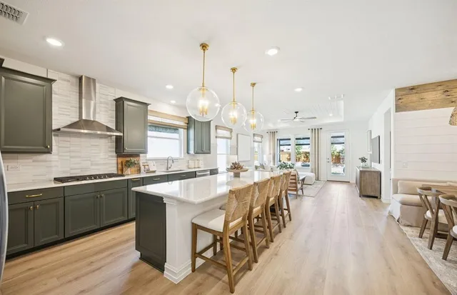 a large kitchen with lots of counter space a sink appliances and living room view