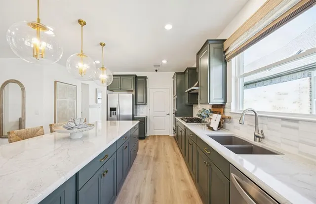 a large kitchen with kitchen island a sink appliances and a counter top space