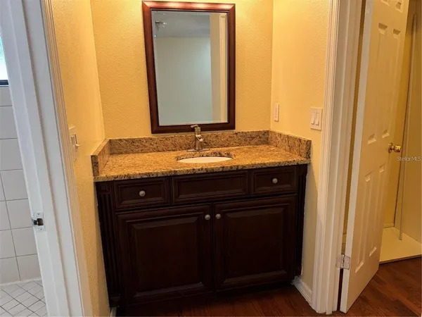 a bathroom with a granite countertop sink and a mirror