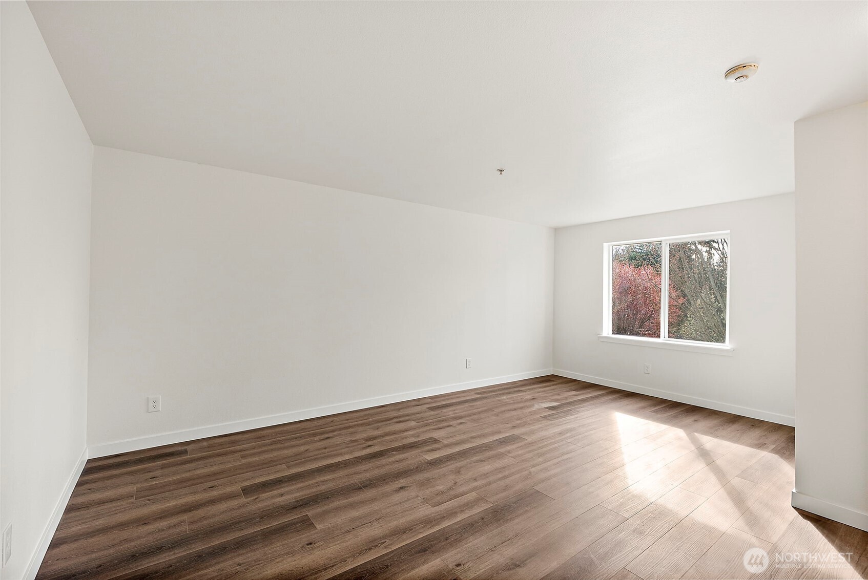 3939 10th Street Southeast, Unit G4 Puyallup, WA 98374 - Photo 11 of 25 a view of an empty room with wooden floor and a window