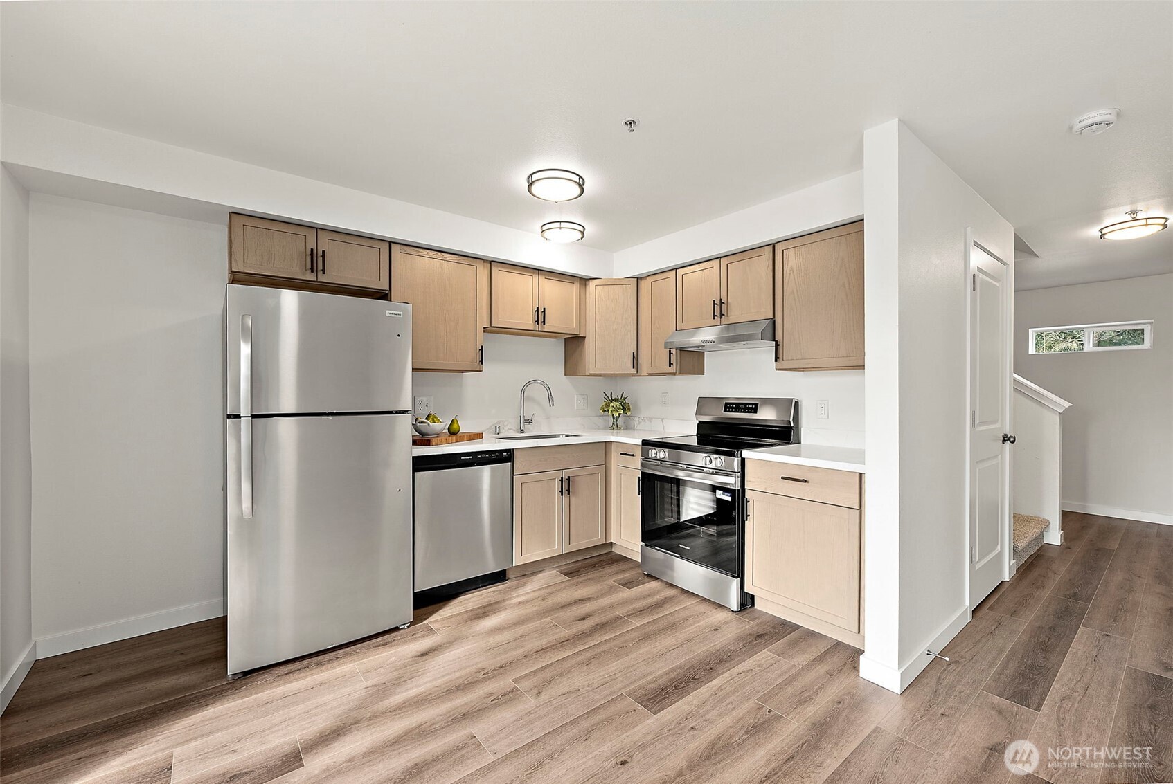 3939 10th Street Southeast, Unit G4 Puyallup, WA 98374 - Photo 5 of 25 a kitchen with a refrigerator a stove top oven and white cabinets