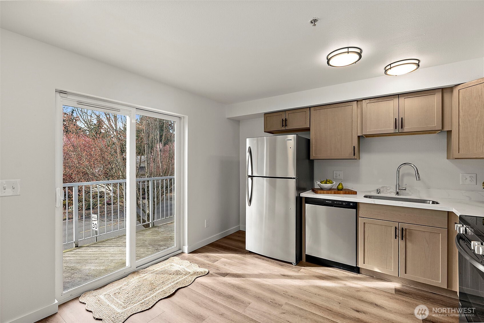 3939 10th Street Southeast, Unit G4 Puyallup, WA 98374 - Photo 6 of 25 a kitchen with a sink a refrigerator and cabinets