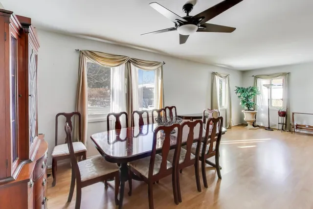 a view of a a dining room with furniture window and wooden floor