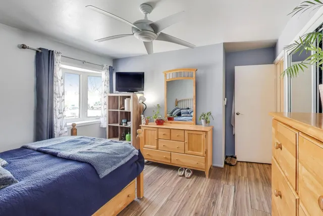 a bedroom with a bed and a flat tv screen on dresser