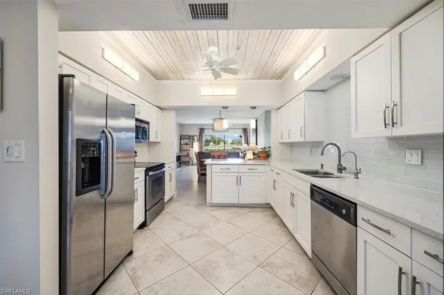 a kitchen with a sink refrigerator and cabinets