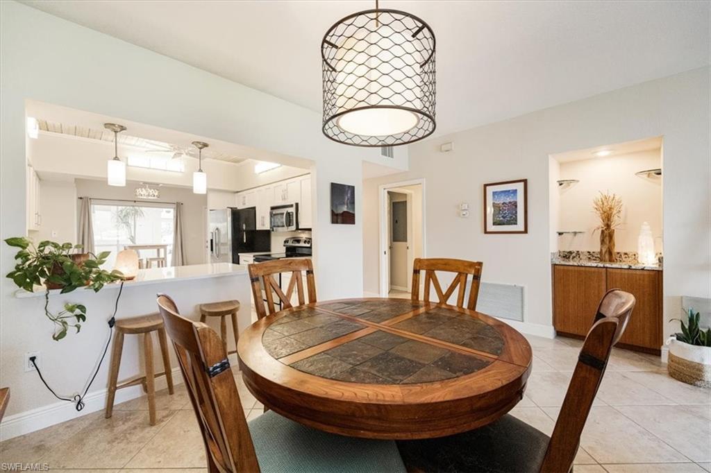 6025 Chardonnay Lane, Unit 103 Naples, FL 34119 - Photo 11 of 45 a dining room with furniture and wooden floor