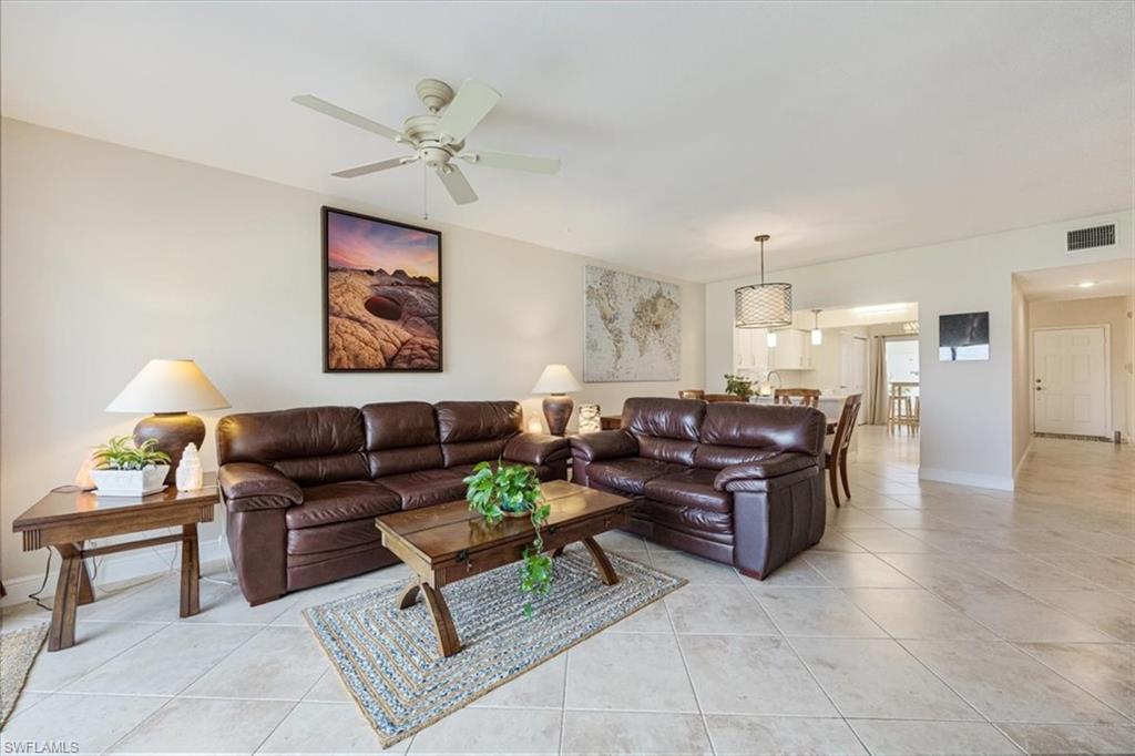 6025 Chardonnay Lane, Unit 103 Naples, FL 34119 - Photo 14 of 45 a living room with furniture and a chandelier