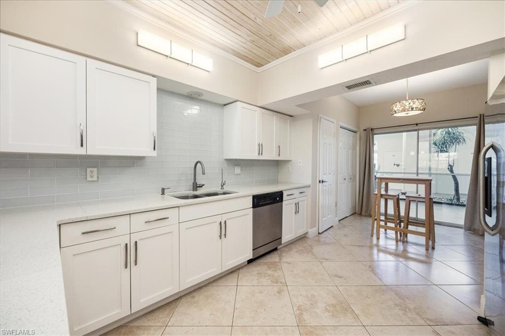 6025 Chardonnay Lane, Unit 103 Naples, FL 34119 - Photo 17 of 45 a kitchen with cabinets and chairs