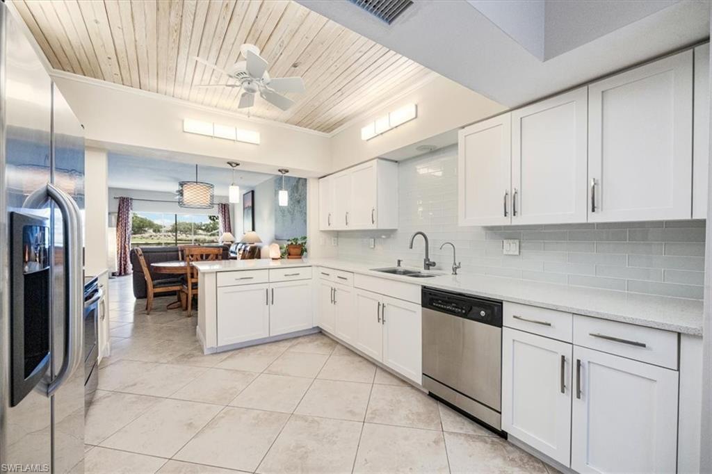 6025 Chardonnay Lane, Unit 103 Naples, FL 34119 - Photo 18 of 45 a large white kitchen with cabinets and stainless steel appliances