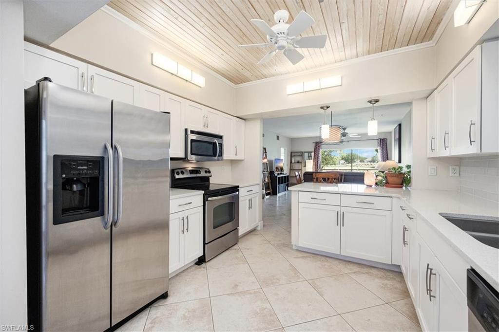 6025 Chardonnay Lane, Unit 103 Naples, FL 34119 - Photo 19 of 45 a kitchen with a sink stainless steel appliances and cabinets