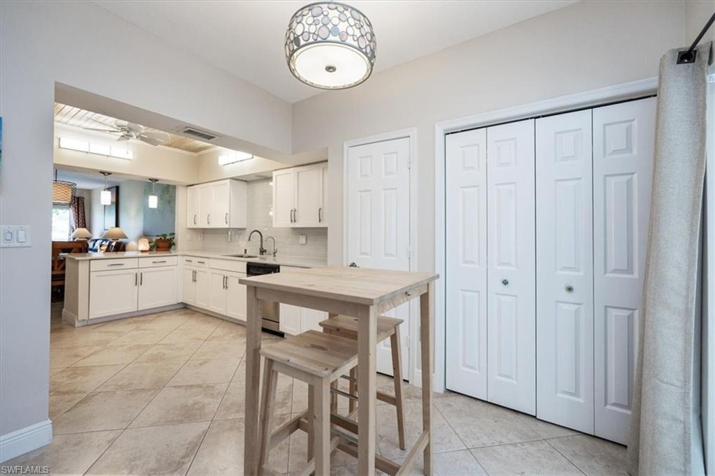 6025 Chardonnay Lane, Unit 103 Naples, FL 34119 - Photo 21 of 45 a kitchen with a table and chairs