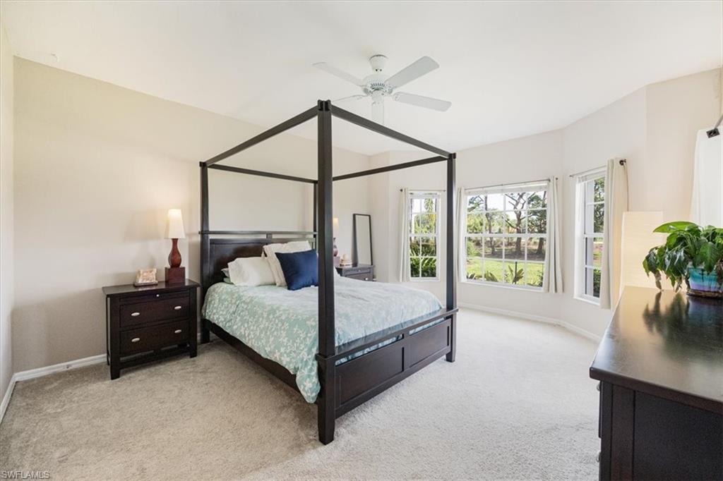 6025 Chardonnay Lane, Unit 103 Naples, FL 34119 - Photo 22 of 45 a bed room with a bed and a potted plant
