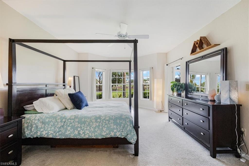 6025 Chardonnay Lane, Unit 103 Naples, FL 34119 - Photo 23 of 45 a bedroom with a large bed and a large mirror