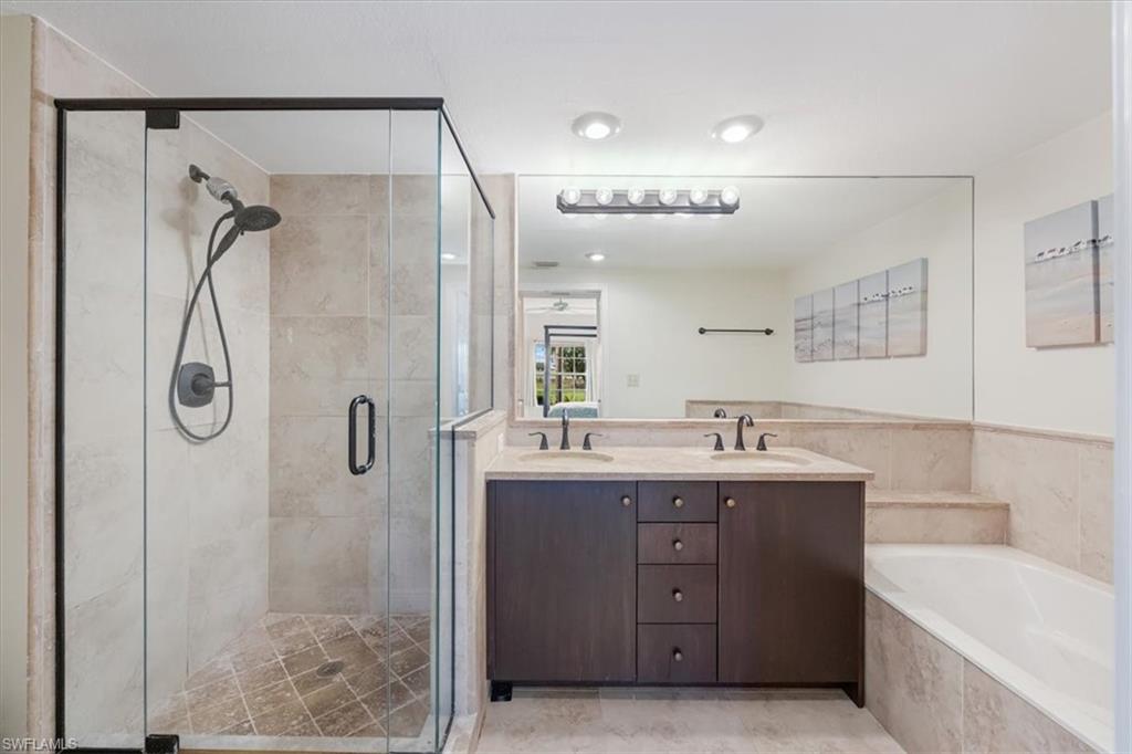 6025 Chardonnay Lane, Unit 103 Naples, FL 34119 - Photo 26 of 45 a bathroom with a double vanity sink mirror and shower