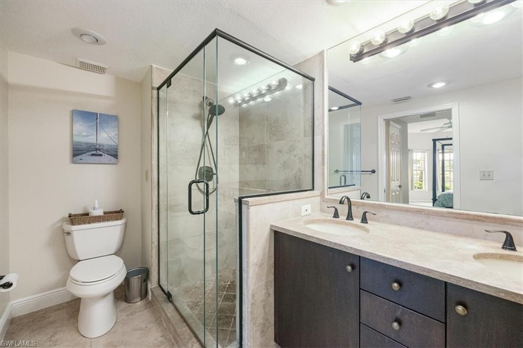 6025 Chardonnay Lane, Unit 103 Naples, FL 34119 - Photo 28 of 45 a bathroom with a granite countertop sink toilet and shower
