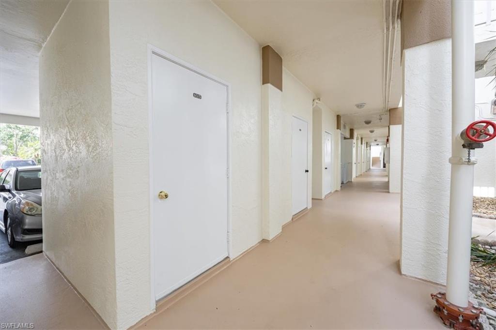 6025 Chardonnay Lane, Unit 103 Naples, FL 34119 - Photo 34 of 45 a view of a hallway with a view of bedroom with a hallway and wooden floor