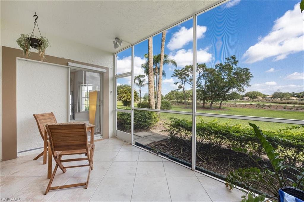 6025 Chardonnay Lane, Unit 103 Naples, FL 34119 - Photo 35 of 45 a view of a chairs and table in the patio and a yard