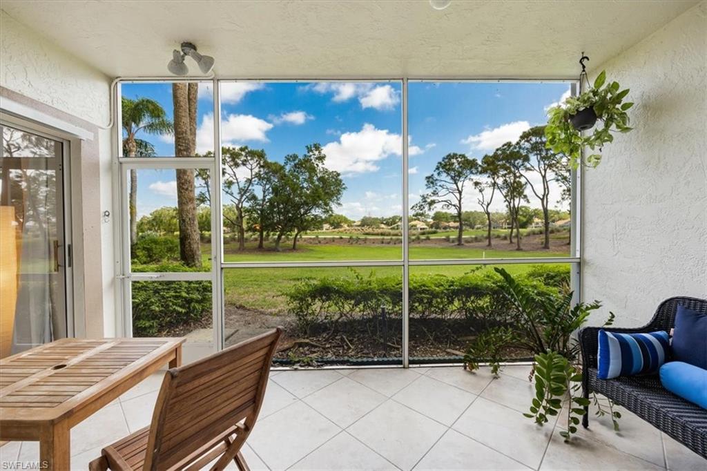 6025 Chardonnay Lane, Unit 103 Naples, FL 34119 - Photo 4 of 45 a view of a chairs and table in patio with wooden fence