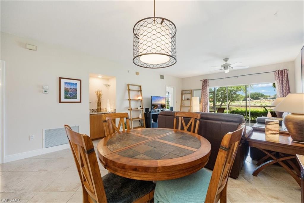 6025 Chardonnay Lane, Unit 103 Naples, FL 34119 - Photo 10 of 45 a dining room with furniture a window and a chandelier