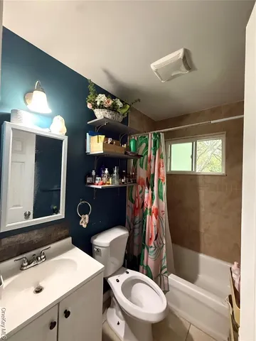 a bathroom with a sink a toilet a mirror a vanity and shower