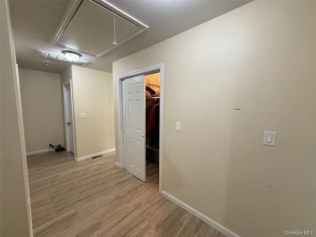 an empty room with wooden floor and a ceiling fan