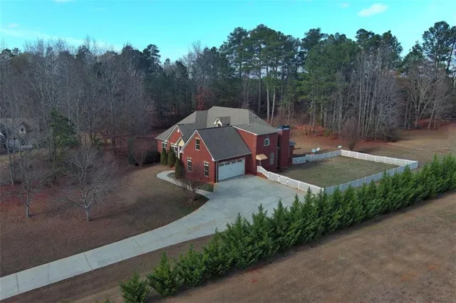 an empty room with wooden floor ceiling fan and windows