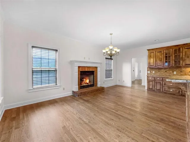 a view of wooden floor and a chandelier fan in a room
