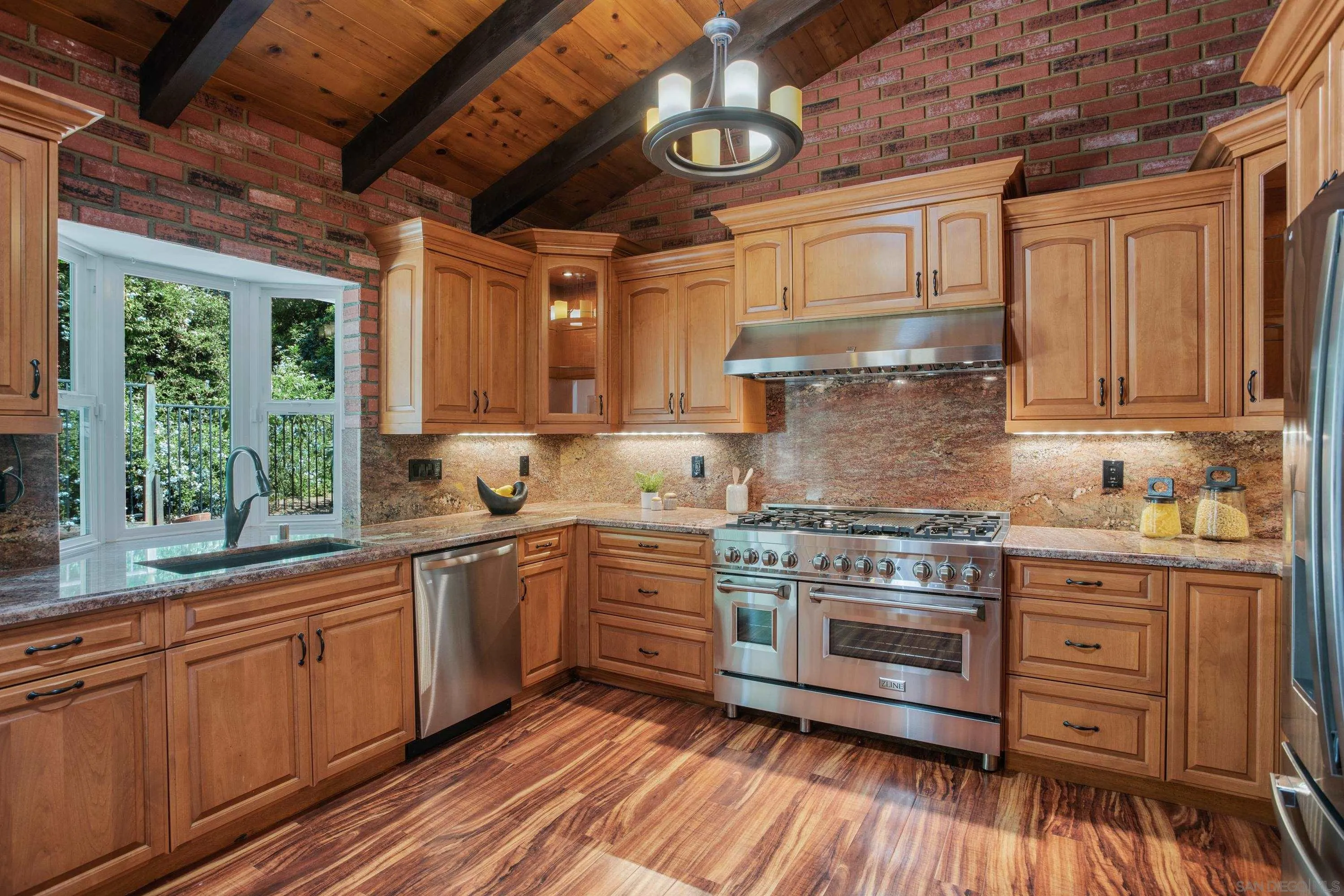16355 Orchard Bend Road Poway, CA 92064 - Photo 13 of 49 a kitchen with stainless steel appliances granite countertop a stove a sink dishwasher and white cabinets with wooden floor