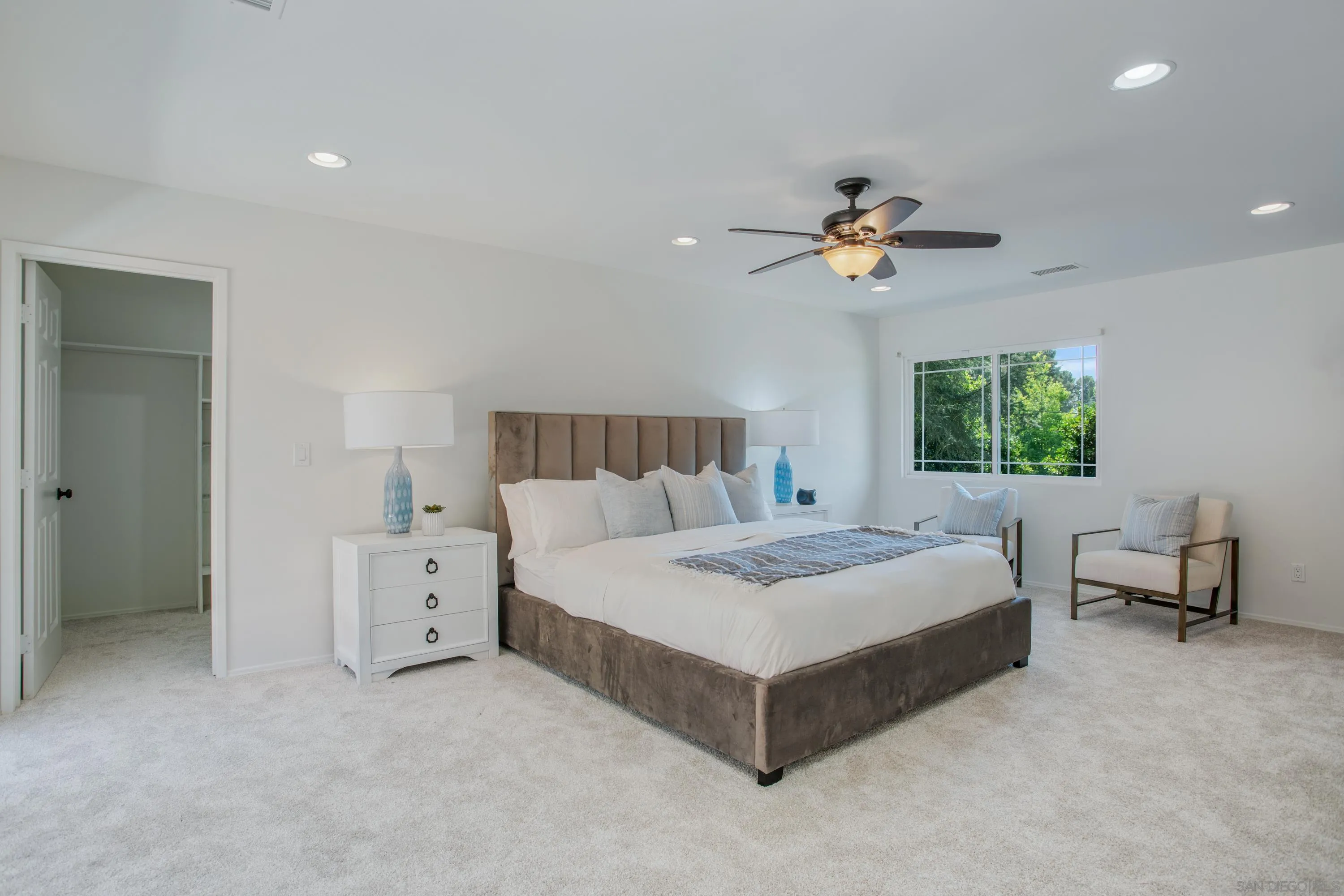 16355 Orchard Bend Road Poway, CA 92064 - Photo 16 of 49 a spacious bedroom with a bed and a chandelier