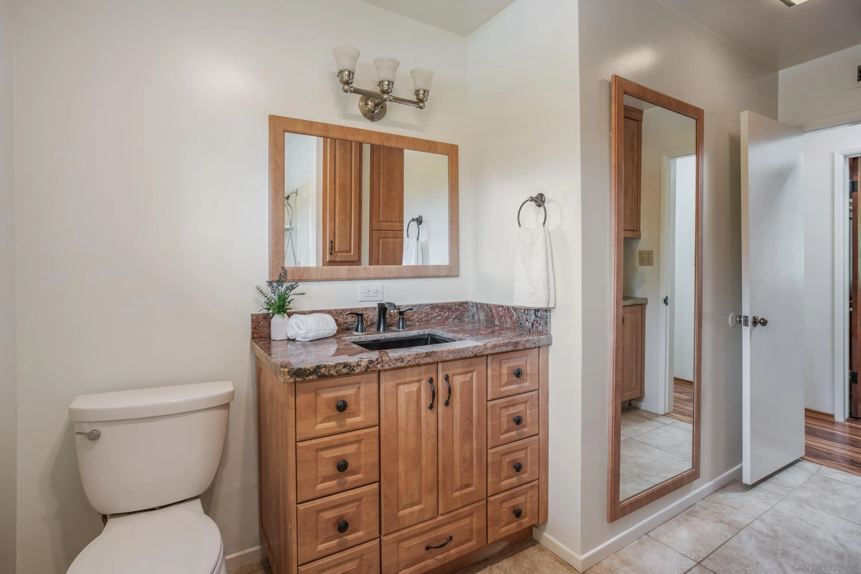 16355 Orchard Bend Road Poway, CA 92064 - Photo 23 of 49 a bathroom with a granite countertop toilet a sink and a mirror
