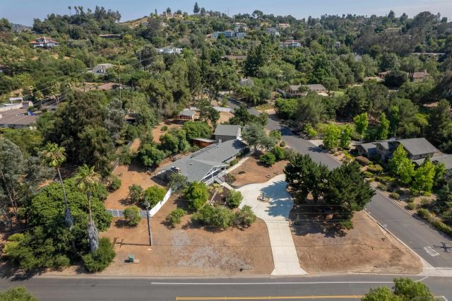 an aerial view of a house with a yard and outdoor seating