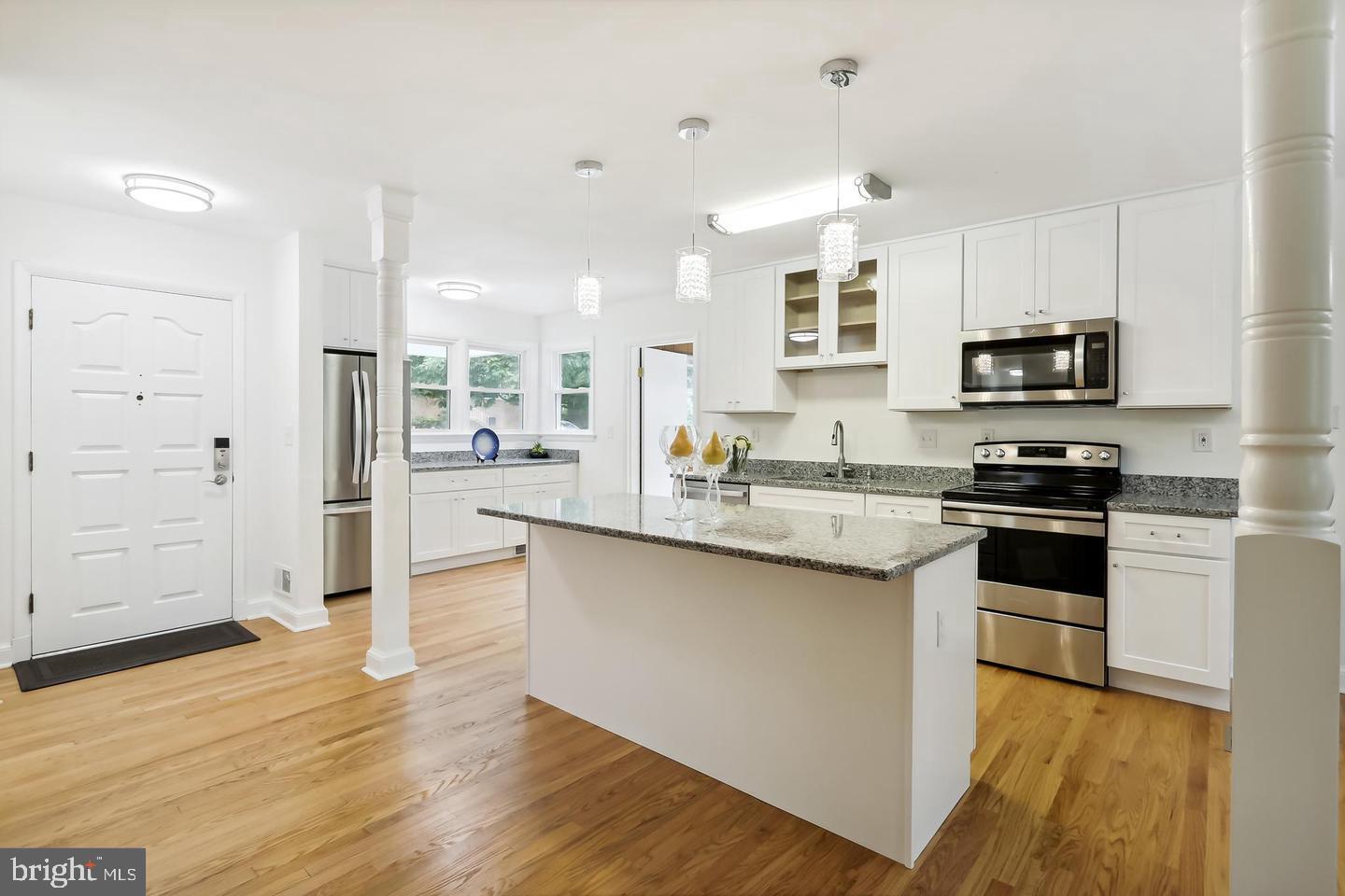 1702 Franwall Avenue Silver Spring, MD 20902 - Photo 8 of 17 a kitchen with stainless steel appliances granite countertop a stove top oven a sink and white cabinets