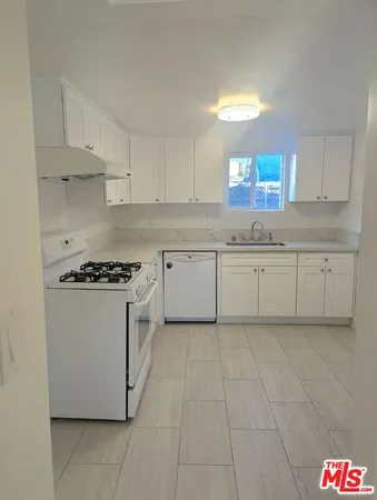 a kitchen with granite countertop white cabinets and white appliances