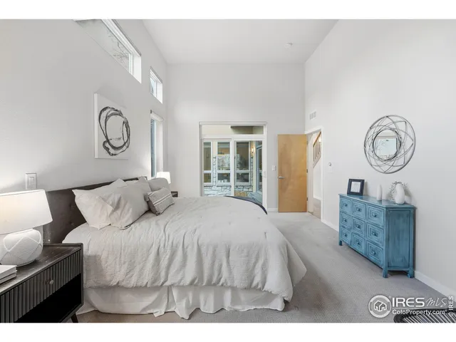 a bedroom with a bed mirror and a window