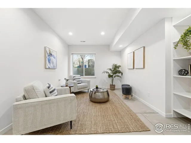 a living room with furniture potted plant and window